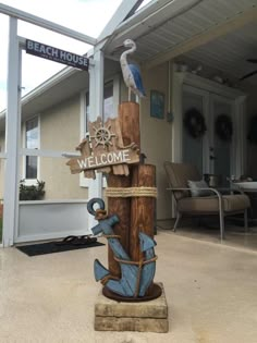 a welcome sign with a bird sitting on it's post in front of a house