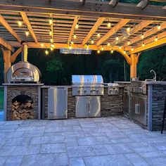 an outdoor kitchen with grills and lights