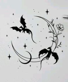 a black and white photo of a crescent with bats on it, stars and flowers