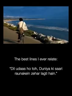 a man riding a bike down a street next to the ocean