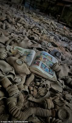 an open book laying on top of a pile of old shoes