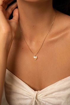 The Lise pearl heart necklace is handcrafted with a heart shaped freshwater pearl and a delicate heart chain. A perfectly classic romantic piece, easy to dress up or down.  14K gold-filled heart chain Heart-shaped freshwater pearl Hypoallergenic, suitable for even the most sensitive skin Each piece is delivered in a silk bag inside a gift box Sustainable packaging   Please note, as we use only natural pearls, shape and size may vary slightly.  We offer a one year guarantee from the date of deliv Elegant 14k Gold Filled Heart Necklace, Dainty Gold Heart-shaped Pearl Necklace, Gold Pearl Necklace With Heart Pendant And Beads, Dainty Gold Pearl Necklace With Heart Beads, Gold Heart Necklaces With Pearl Charm, Feminine Gold Heart Pendant Necklaces, Dainty Heart Necklace With Pearl Chain, Gold Dainty Heart Necklace With Pearl Charm, Dainty Gold Pearl Necklace With Heart Pendant