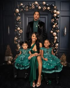 the family is posing for a photo in front of a christmas wreath with ornaments on it