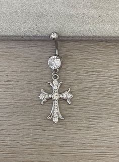 the cross is attached to an earring with crystal stones on it's side