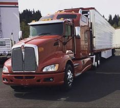 a red semi truck parked in a parking lot