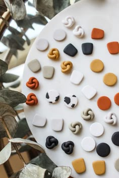 the instagram page for polymer jewelry is displayed on a white plate with orange and black beads