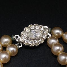 *Description: This is a beautiful creamy glass pearl two strand choker necklace from the 1940s with rhodium plated pendant and seven rows of graduated glass pearls with a seed bead on the end of each. This early mid century necklace would be beautiful on a bride or any wedding formal outfit. Pearls are classic to wear with so many outfits. The pendant is gorgeous with five emerald cut clear rhinestones and the rest of the pendant is covered with clear pave rhinestones. The back is rhodium plated Vintage Pearl Pendant Jewelry With Round Beads, Vintage Pearl Drop Jewelry For Vintage Events, Vintage Double Strand Pearl Necklace, Vintage Double Strand Pearl Necklace For Anniversary, Vintage Cream Pearl Drop Jewelry, Vintage Pearl Necklace With Pearl Drop For Anniversary, Vintage Pearl Drop Necklace For Anniversary, Vintage Single Strand Pearl Necklace, Vintage Silver Pearl Necklace For Anniversary