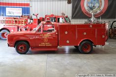 an old red fire truck parked in a garage