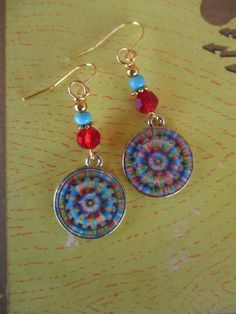 ♥Jewelry designs made by hand with heART♥ These beautiful tie dye design mandala charm earrings feature red Swarovski crystal beads, brass accent beads and seed beads which compliment the mandala charm. Lovely, FUN, Hippie Days lightweight earrings. These earrings measure 2 inches from the top of the ear wires. Handmade and ready to ship. Ready to give away or to treat yourself! Enjoy ♥ Thank you for visiting ♥third time charms♥ Multicolor Nickel-free Crystal Earrings For Gift, Multicolor Metal Jewelry With Ear Wire, Bohemian Multicolor Hypoallergenic Earrings, Bohemian Multicolor Hypoallergenic Jewelry, Artistic Multicolor Hypoallergenic Jewelry, Bohemian Round Clip-on Earrings As Gift, Multicolor Nickel-free Dangle Earrings, Nickel-free Multicolor Dangle Earrings, Multicolor Jewelry With Matching Round Earrings