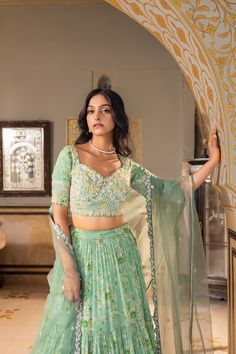 Unleash your inner diva with this stunning green layered lehenga set by Suruchi Parakh! Meticulously crafted from georgette and net fabrics, this ensemble features intricate hand embroidery that exudes elegance and sophistication. The matching blouse and dupatta come with exquisite pearl detailing, adding a touch of timeless luxury. Whether it’s a wedding or a festive celebration, this masterpiece is sure to make you the center of attention! Pista Green Fitted Blouse Piece With Sheer Dupatta, Pista Green Fitted Lehenga With Unstitched Blouse, Green Georgette Lehenga With Cutdana Details, Semi-stitched Pista Green Lehenga With Sheer Dupatta, Unstitched Pista Green Lehenga With Cutdana, Off Shoulder Lehenga, Lehenga Green, Ruffle Lehenga, Ceremonial Clothing