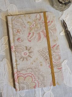 Pocket Notebook covered in charming paisley fabric - Ruled Pages You will enjoy filling the smooth and fountain pen friendly pages of our beautiful pocket notebooks.  Covered in a selection of gorgeous French and vintage fabrics, they are expertly hand-bound in the UK with great attention to detail. Each one is unique and would make a wonderful gift for pen and paper lovers.  This pocket notebook is covered in a delightful paisley fabric in delicate colours. Finished with ribbon page marker and matching elastic closure, it is perfect for those who prefer writing on ruled paper, and will fit nicely inside a handbag. An address book in the same fabric is available separately (shown on the last photograph). 160 pages of 100gsm top quality ivory ruled paper  9.5 x 14.5 cm approx. As is to be e