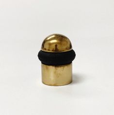 a gold and black knob on a white surface