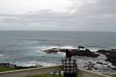 a person sitting on a bench looking out at the ocean