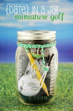 a jar filled with money sitting on top of a green grass covered field next to an iphone