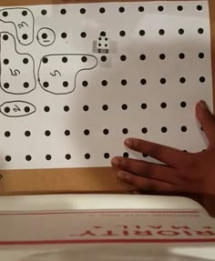 a hand is pointing at a piece of paper with black dots on it that says, i love you