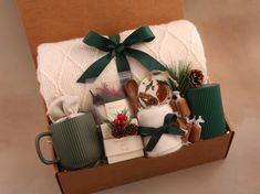 a christmas gift box filled with gifts and coffee mugs