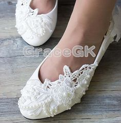 a woman wearing white shoes with lace on them