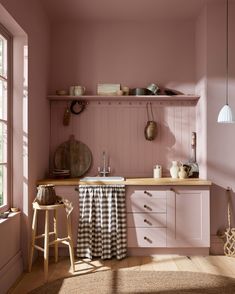 a kitchen with pink walls and wooden floors