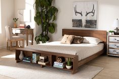 a bedroom with a bed, dresser and plant