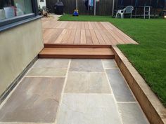 a wooden deck in the middle of a yard