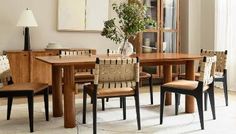 a dining room table with four chairs and a vase on the table in front of it