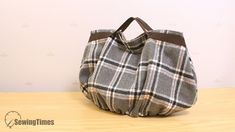 a handbag sitting on top of a wooden table next to a white and brown wall