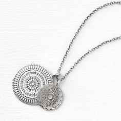 a coin necklace that revives the layered style. our double medallion pendant has two hand-stamped patterned coins strung on an 18" chain, ideal for layering with others in our medallion collection. materials + dimensions sterling silver to brighten, polish with a clean cloth avoid all chemicals + abrasives Medallion Locket Charm Necklace In Amulet Style, Sterling Silver Medallion Charm Necklace With Coin Pendant, Sterling Silver Coin Pendant Charm Necklaces, Engraved Medallion Amulet Charm Necklace, Nickel-free Sterling Silver Medallion Necklace, Nickel-free Round Pendant Coin Necklace In Amulet Style, Sterling Silver Coin Medallion Necklace Nickel Free, Silver Amulet Charm Necklace With Coin Pendant, Bohemian Medallion Coin Necklace, Engraved