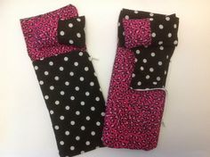 two black and pink polka dot oven mitts on a white table with one in the middle