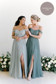 two women standing next to each other in dresses