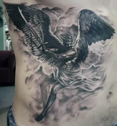 a man's back with an angel tattoo on his stomach and wings flying above him