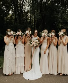 a group of women standing next to each other holding bouquets in front of them