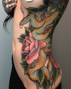 a woman's stomach with a snake and rose tattoo on it