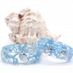 Ocean seashell & starfish ring  Resin ring with silver shell inlay. The color blue of the resin ring symbolizes love, inspiration and wisdom. Blue is the most pleasing color for the human eye, plus it embodies the powers of nature like nothing else. The oceans a calm presence and sense of space, a place to reflect on the past, and to dream and hope about the future. The ocean is a powerful symbol. Throughout history, it has been seen as a symbol of power and strength. Today, it is often seen as a symbol of mystery, endlessness, calmness, hope, and even truth. These rings are perfect for people that love natural & oceanic styles.  I offer Sizes 4-16. Choose your size from the size options above.  Each piece in my shop are handmade by me. They are each unique and different, no piece can be r Blue Starfish Jewelry For Beach, Ocean-inspired Shell Rings For Beach, Blue Starfish Beach Jewelry, Ocean-inspired Blue Shell Jewelry, Ocean-inspired Promise Ring, Ocean-inspired Silver Rings For The Beach, Blue Shell-shaped Beachy Jewelry, Ocean-inspired Shell-shaped Rings As Gift, Blue Shell-shaped Jewelry For Vacation