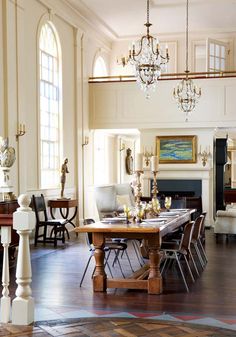 an elegant dining room with chandelier, chairs, and table in the center