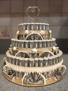 a wedding cake made out of money with a heart on top