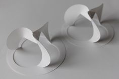 three pieces of white paper are arranged in the shape of an o - shaped object