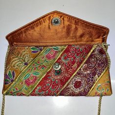 This is a New Handmade Purse/clutch in Vintage Style. It is made by vintage fabrics. It is multi-color purse. It is Beautifully decorated with vintage fabric, Sequins, Mirror and thread embroidery work along with nice print. It is containing a magnetic button enclosure and a tread chain string for easy carrying. It is contained two zipper pockets inside the bag. You can use this purse for marriage, Parties and Gifting purpose. The image may show slight differences to the actual bag in color, shape and texture. Bag Sizing (in Inches) approx. Length: "30approx. Width:   17"approx. The color may slightly differ due to different computer color setting. Shipping Policy: - We ship worldwide from India.  We ship parcels through Standard Shipping Service of India Post which provides proper trackin Party Multicolor Embroidered Rectangular Shoulder Bag, Party Rectangular Shoulder Bag With Multicolor Embroidery, Embroidered Multicolor Clutch For Party, Embroidered Multicolor Clutch Evening Bag, Multicolor Evening Bag With Zari Work, Traditional Multicolor Shoulder Bag For Formal Occasions, Formal Embroidered Multicolor Clutch, Multicolor Evening Clutch With Zari Work, Evening Multicolor Clutch With Zari Work