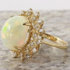 6.90 Carats Natural Impressive Ethiopian Opal and Diamond 14K Solid Yellow Gold Ring Suggested Replacement Value: $6,800.00 Total Natural Opal Weight is: Approx. 6.00 Carats Opal Measures: Approx. 15.38 x 12.07mm The head of the ring measures: Approx. 21.14 x 20.63mm Total Natural Round Diamonds Weight: Approx. 0.90 Carat (color G-H / Clarity SI1-SI2) Ring total weight: Approx. 5.9 grams Disclaimer: all weights, measurements and colors are approximate and may vary slightly from the listed dimens Formal White Diamond Gemstone Ring, Formal Multi-stone Diamond Opal Ring, Formal Multi-stone Opal Ring With Diamonds, Formal Opal Ring, Elegant Yellow Gold Opal Ring For Formal Occasions, Elegant White Cluster Ring Gia Certified, Elegant White Gia Certified Cluster Ring, Pear-shaped Opal Ring For Formal Occasions, Formal Opal Ring With Diamond Round Cut