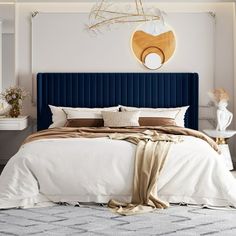 a bedroom with a blue headboard and white walls