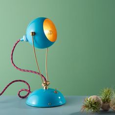 a blue table lamp sitting on top of a desk next to an airplant