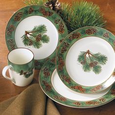 a table topped with plates and cups filled with pine cones