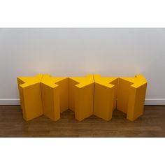 four yellow boxes sitting on top of a hard wood floor next to a white wall