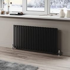 a radiator in the corner of a room next to a window with snow outside