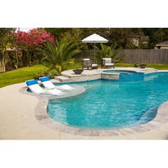 an empty swimming pool with lounge chairs around it