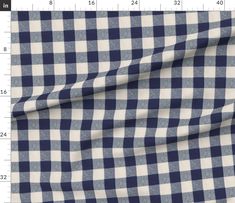 a blue and white checkered fabric with a ruler in the foreground, on top of it