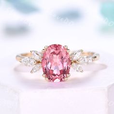 a pink diamond ring with three white diamonds