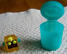 a blue glass bottle sitting on top of a table next to a small yellow object