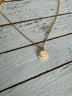 The sweetest necklace ever….featuring a hand stamped heart set on a larger stamped disc and a dainty chain, this little beauty goes with everything! Material is 14k gold filled. Chain measures 16” Handmade at the time you order. Dainty 14k Gold Filled Engraved Charm Necklaces, Dainty Engraved 14k Gold Filled Charm Necklaces, Dainty 14k Gold Filled Engraved Charm Necklace, Dainty Hand Stamped Necklaces For Anniversary, Dainty Hand Stamped Charm Necklaces For Everyday, Dainty Hand Stamped Charm Necklace For Everyday, Everyday Engraved 14k Gold-filled Charm Necklace, Everyday Engraved 14k Gold Filled Charm Necklace, Gold Hand Stamped Charm Necklace For Valentine's Day