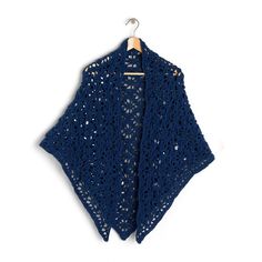 a blue crocheted shawl hanging on a hanger