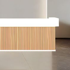 an orange vase sitting on the floor next to a white wall with vertical lines painted on it